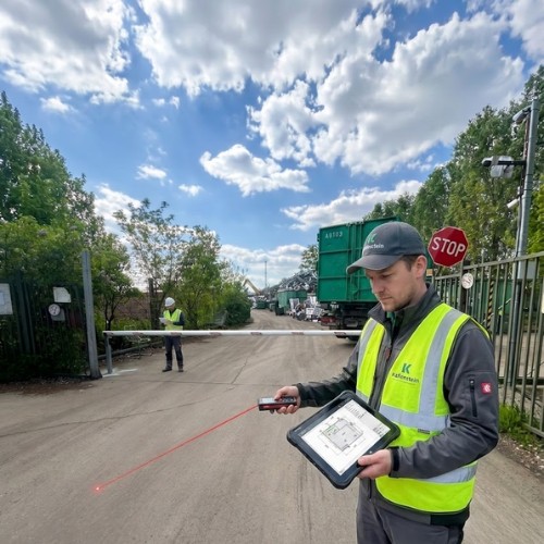 Ipari sorompó kivitelezés - 2. lépés: helyszíni felmérés lézeres távolságmérővel és digitális tervrajzot mutató ipari tablettel egy üzemi telephely beléptető kapujánál – Koffenstein Kaputechnika Kft.